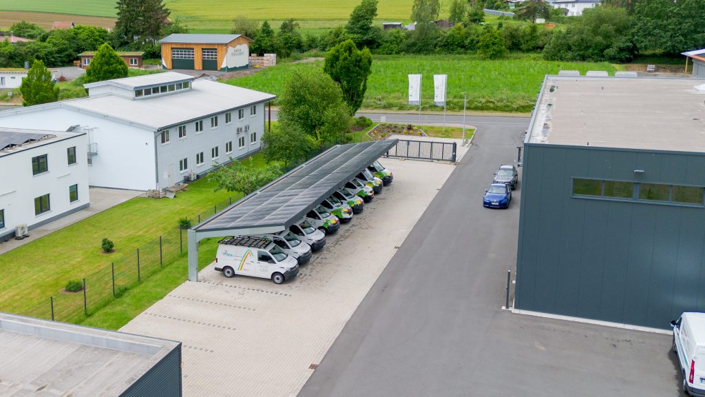 Solarcarport mit Photovoltaikanlage zur nachhaltigen Stromerzeugung für eine Firmenflotte auf einem Unternehmensgelände.